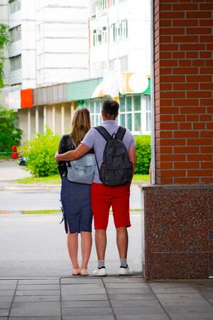 Back view of beautiful couple hugging and hide from the rain.の写真素材