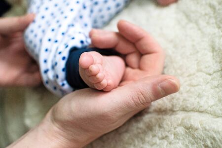 Little baby feet in dad's strong and caring hand.