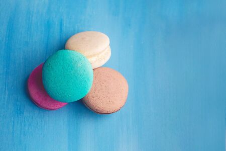 Sweet and bright colourful macarons on blue background. Tasty french sweets.の写真素材