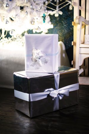 New Years and Christmas gift boxs under the fir-tree. Holiday greeting card.
