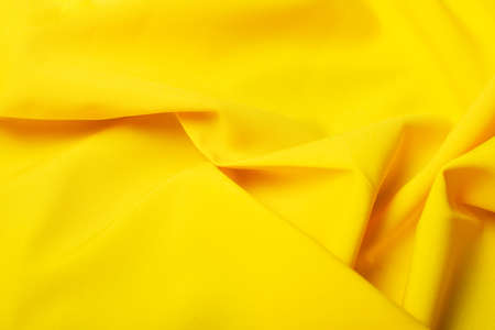 Beautiful yellow satin as a background, soft yellow abstraction. Selective focus. Color 2021.の写真素材