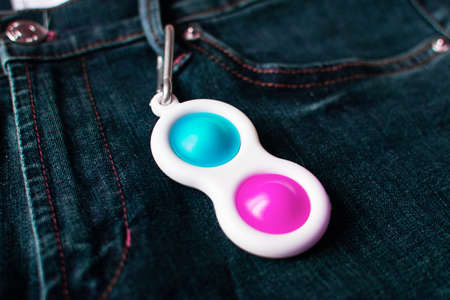 Bright pink and blue toy antistress for children and adults on a colorful background. Flexible...