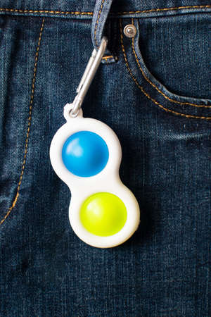 Bright yellow and blue toy antistress for children and adults on denim background. Flexible sensory...