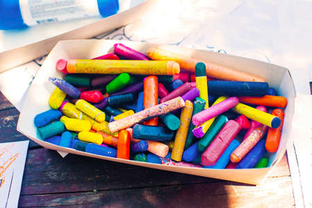 A box with colored wax crayons on the table, colored pencils. Materials for children's creativity.