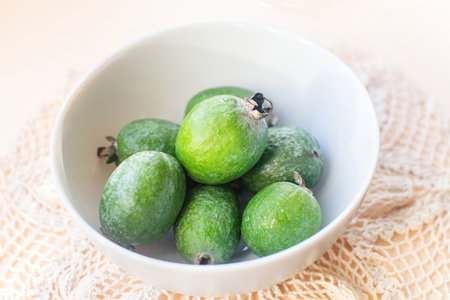 Fresh green feijoa fruit or Acca sellowiana in bowl on the table.の写真素材