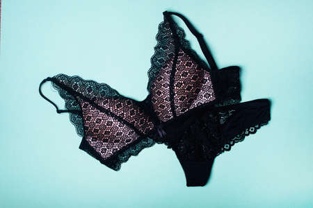 Beautiful black sports top bra and panties - thongs. Black lace lingerie on green background.の写真素材