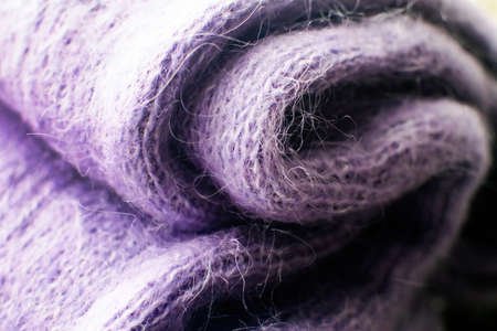 Texture of violet wool knitted as background. Knitted woolen sweater. Color 2022.