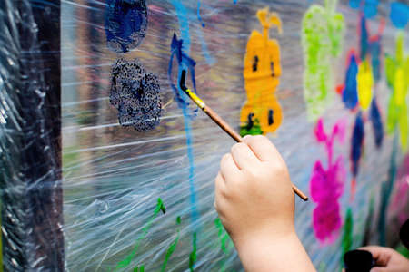 Idea for a game with a child: childrens drawing with paints on polyethylene.