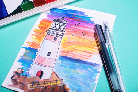 Lighthouse on coast of sea. Hand drawn beacon. Sketch with paints and pens on the table.