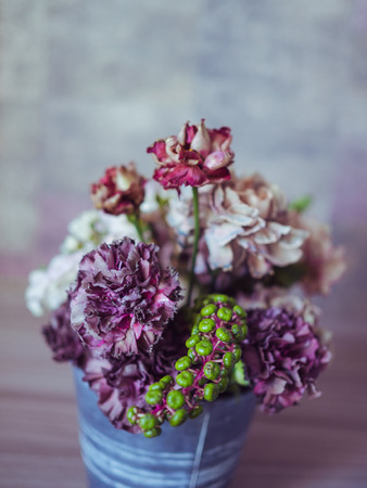 A beautiful bouquet of flowers a on a table with and multicolour background. Side view, selected focus.の写真素材