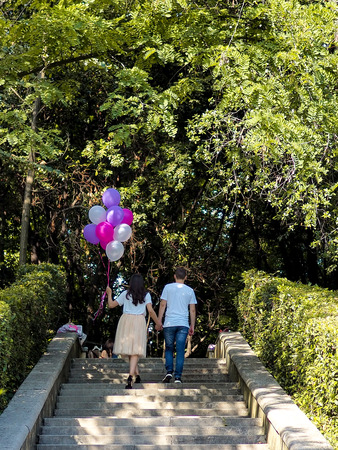Young couple in love at the rest on the nature. man and woman outdoors. colourful ballons. hands together. close up. stairs on backgroundの写真素材