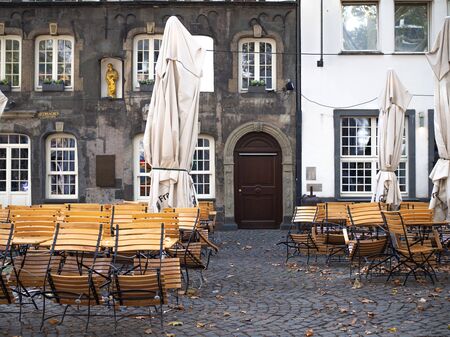 Germany, Cologne - October 2018. Sunny street, multicolored buildings, cozy cafes, city life. Open air cafe near downtownのeditorial素材