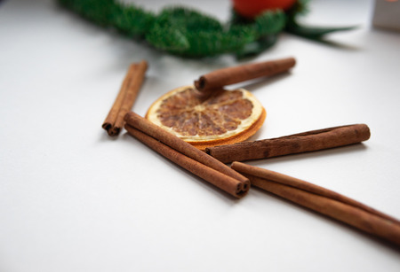 Christmas composition. Cinnamon stick, orange on white background. Flat lay, top view, copy space