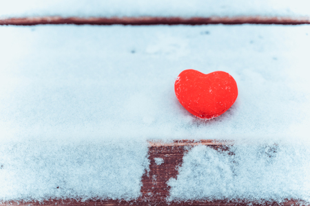 Female hands in knitted white mittens with heart of snow in winter day. Love and St. Valentine cozy concept, copyspaceの写真素材