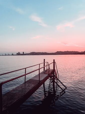 Side view of a wooden pier on the sea at sunset, Durres, Albania. Awesome sunset skyの写真素材
