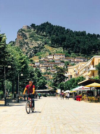 Berat, Albania- June 2018: Modern part of Berat city in Albania, cyclist goes down the streetのeditorial素材