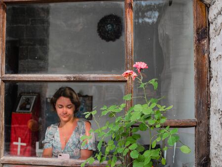 BERAT, ALBANIA - June, 2018: insight the old church, lights and shadow, toned Girls with phone in the window.のeditorial素材