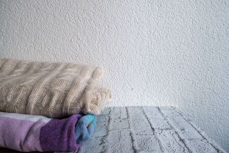 Folded knitted plaid on white background. Warm and cozy home, selected focusの写真素材