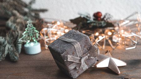Holiday card with new year decoration, fir tree branches and gift box on white and wooden background.の写真素材