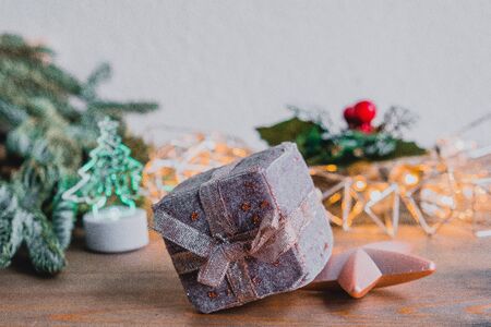 Holiday card with new year decoration, fir tree branches and gift box on white and wooden background.の写真素材