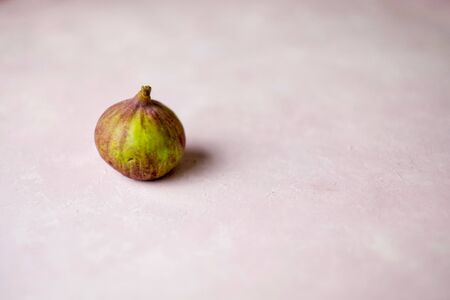 whole fig on a light pink marbled background with copy space. Selected focusの写真素材