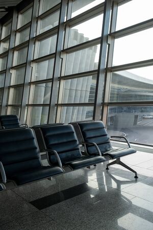 There are empty chairs, benches for passengers waiting for flights at the airport terminal, selected...