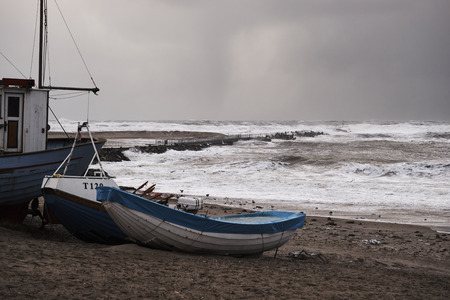 fishing boat on the beach during storm in Nr. Vorupør on the North Sea coast in Denmark