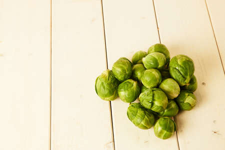 Bunch of fresh raw Brussel sprouts on a white wood tableの写真素材