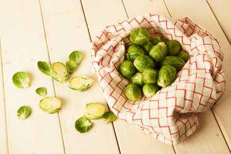 Bunch of fresh raw Brussel sprouts on a white wood tableの写真素材