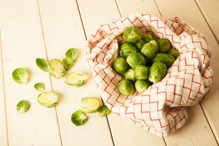 Bunch of fresh raw Brussel sprouts on a white wood tableの写真素材