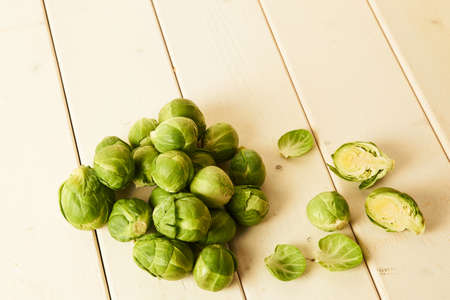 Bunch of fresh raw Brussel sprouts on a white wood tableの写真素材