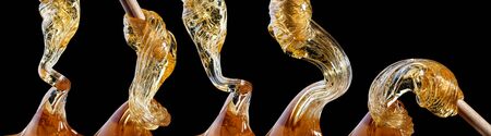 Viscous thick liquid flows close-up isolated on black backgroundの写真素材