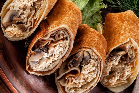Pancakes with chicken and mushrooms on a lettuce leaf close-upの写真素材