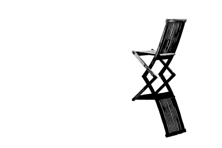 Old wooden chair in calm water with reflection, symbolizing pease, loneliness and emptynessの写真素材