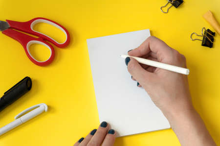 Creative workspace background mockup with hand holding a pen. Stationery set. Back to school. Top...