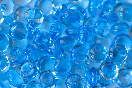Transparent blue glass marble beads. Acrylic ice stones for decoration. Water drops background....