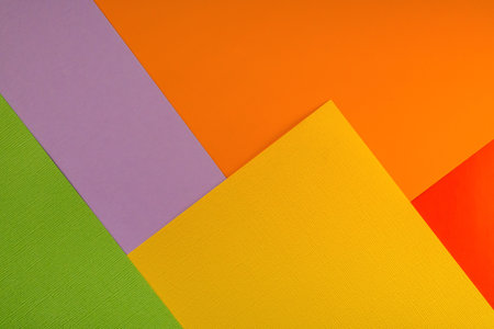 Bright abstract geometric paper background. Green, violet, yellow, red and orange trendy colors. The...