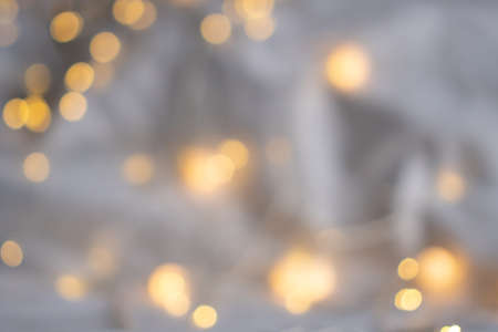 Festive soft background with yellow bokeh of the garland. Light Xmas composition, Christmas theme. The backdrop for web design, greeting, or invitation card. Happy holidays celebrationの写真素材