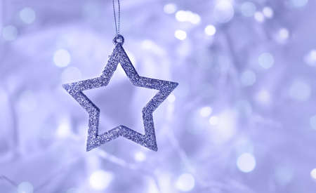 Violet blue shiny star on a soft background with bokeh of the garland. Light Xmas composition, Christmas theme. The backdrop for web design, greeting, or invitation card. Violet blue wallpaperの写真素材