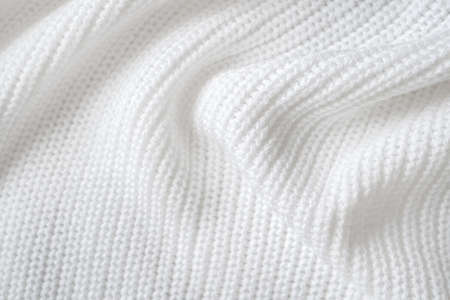 Soft knitted sweater texture closeup. Light abstract background. The trendy white backdrop for web design. Luxury twisted fabric backplate with patternsの写真素材