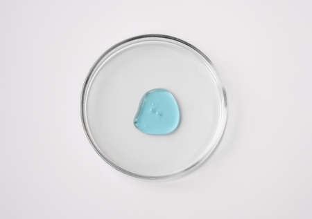 Laboratory glass petri dish with drop of water, serum, oil, beauty product. Natural medicine,...
