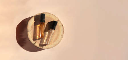 Banner of Perfume samples with yellow transparent liquid on woodcut on beige background. Luxury and natural cosmetic presentation. Testers in sunlight. Shades and lights. Top viewの写真素材