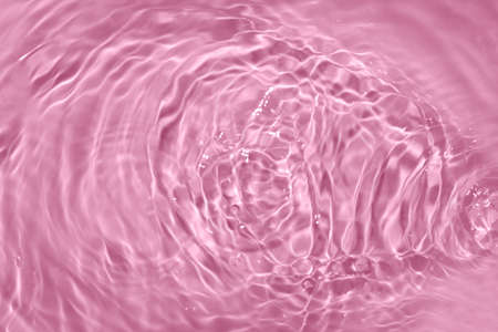 Circles on water. Pink round shadows. Blurred background made with water and light in monochrome. Pureness and freshness concept.の写真素材