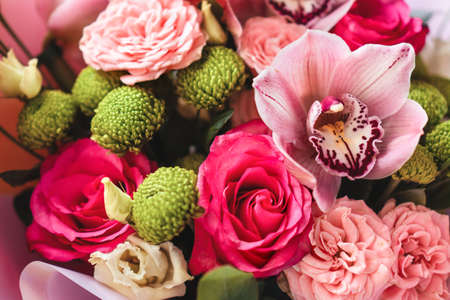 Bright pink flowers bouquet closeup. Roses and orchids wallpaper. Beautiful background for a Birthday, International Female Day, or Saint Valentine. The festive backdrop for a postcard designの写真素材