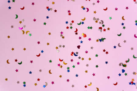 Festive pink background with many colorful stars and moons. Christmas, New Year or Birthday theme concept. An ideal backdrop for your banner or web design. Backplate for happy holidays presentationの写真素材