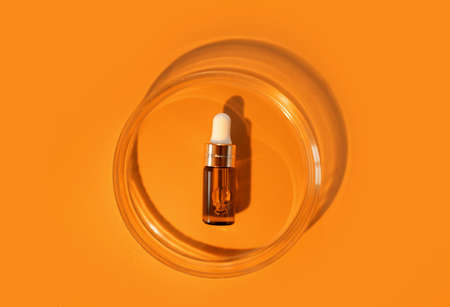 Amber bottle. Laboratory glass petri dish with pipette of water, serum, oil, beauty product. Natural medicine, cosmetic research, bio science. Skincare and analysis concept. Dermatology. Top viewの写真素材
