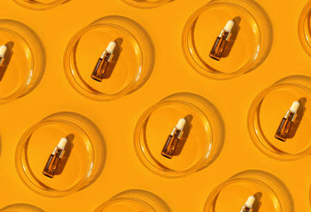 Amber bottle. Laboratory glass petri dish with pipette of water, serum, oil, beauty product. Natural medicine, cosmetic research, bio science. Pattern. Skincare and analysis concept. Dermatologyの写真素材