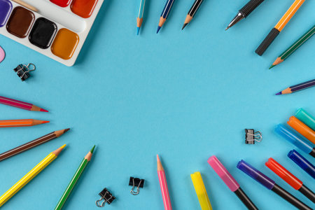 Many stationary supplies on blue background with space for text. Office accessories flat lay. First...
