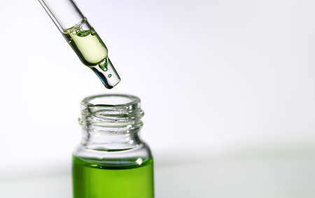 Pipette with transparent fluid hyaluronic acid or serum. Cosmetics, science and healthcare concept...