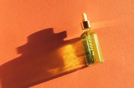 Transparent glass dropper bottle with serum, oil, hyaluron on pink background. Pipette with serum, oil, retinol. Cosmetics, healthcare, beautyの写真素材
